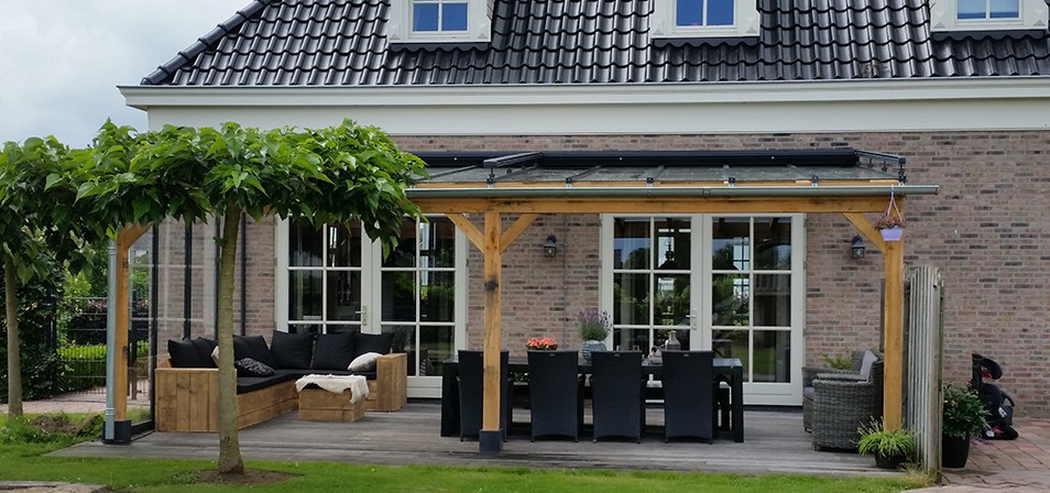 Houten veranda aan huis overkapping glazen dak met zithoek en eettafel