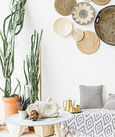 Bohemian interieur kenmerken cactus terra cotta potten rotan schalen aan de wand Bali wanddecoratie aztec kleed boho woonkamer 