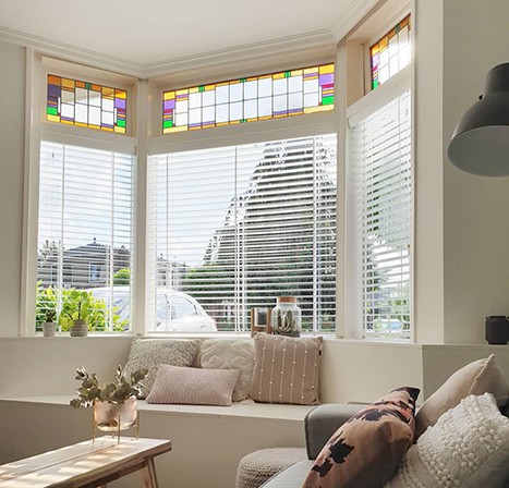 Witte houten jaloezieën erker raambekleding glas in lood jaren 30 woning vensterbank inspiratie